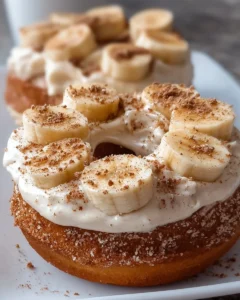 Banana donuts with cinnamon cream cheese frosting on a plate