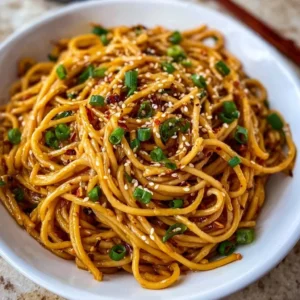 Delicious bowl of Garlic Sesame Noodles topped with fresh herbs and sesame seeds.