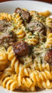 Creamy garlic parmesan steak bite pasta topped with fresh herbs